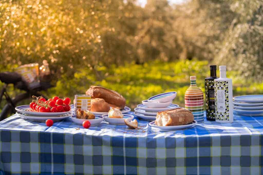 Ingredienti freschi e bottiglie di olio extravergine Frantoio Muraglia pronti per l'abbinamento in cucina