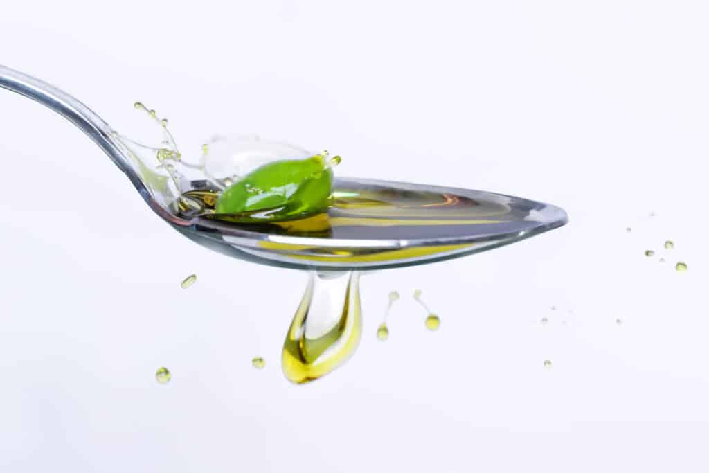 Cucchiaio di olio extravergine di Puglia verde smeraldo ricco di polifenoli