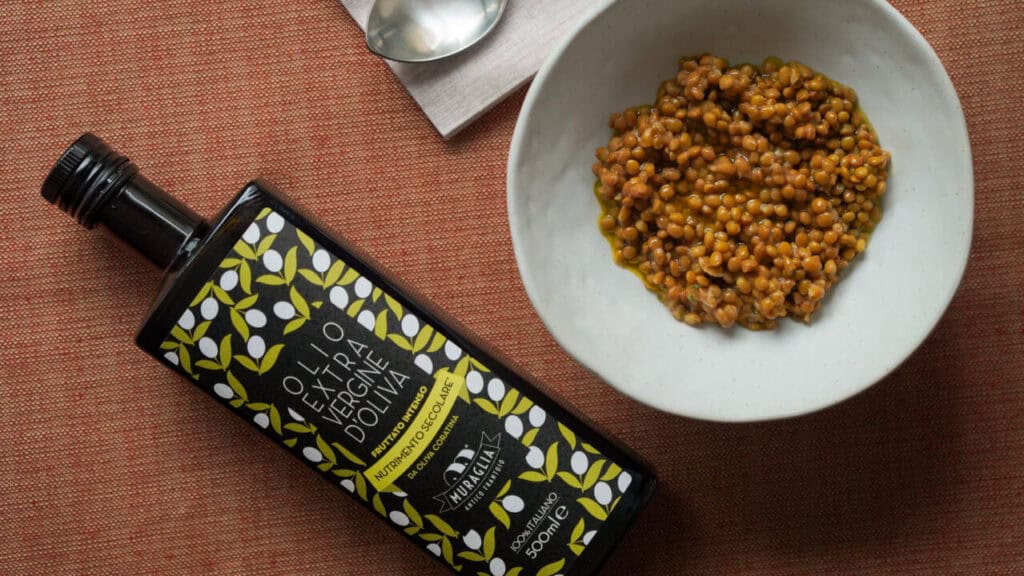 Olio extravergine monocultivar versato a crudo su una zuppa di legumi