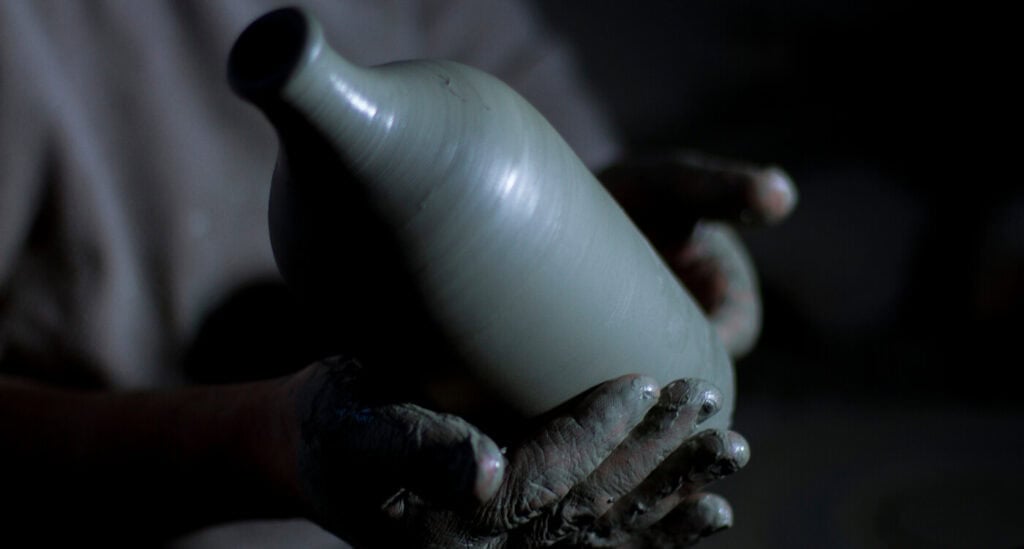 Artigiano pugliese che lavora a mano un orcio per l'olio Frantoio Muraglia