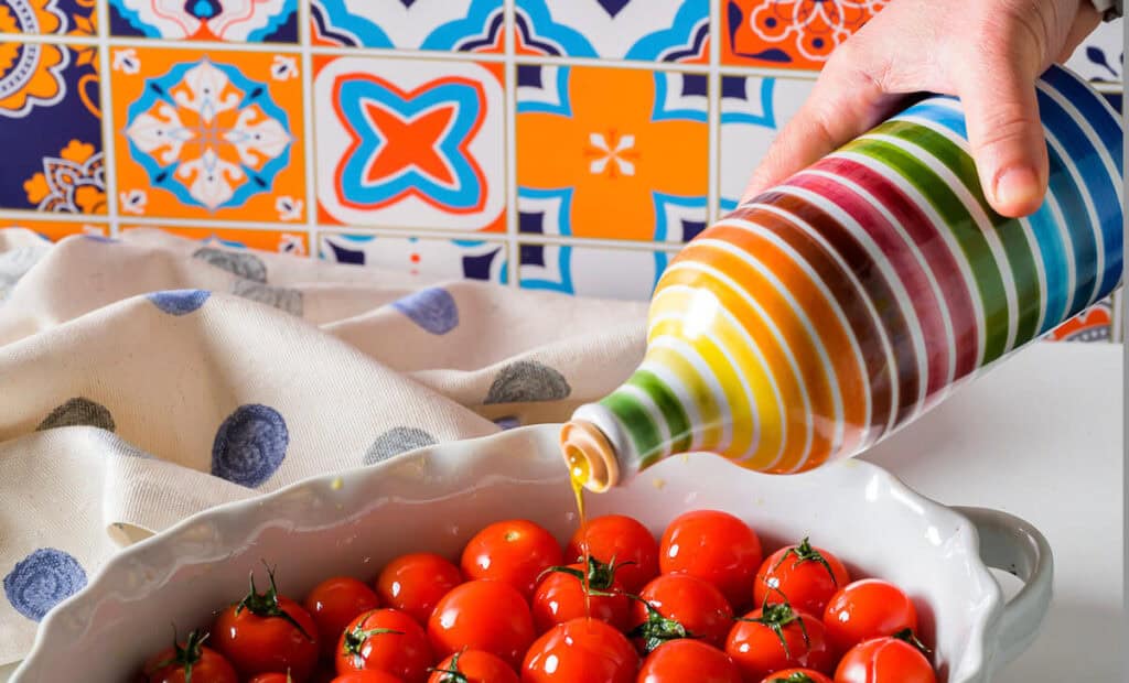 Dettaglio olio extravergine di Puglia del Frantoio Muraglia versato sui pomodori, colore verde oro intenso