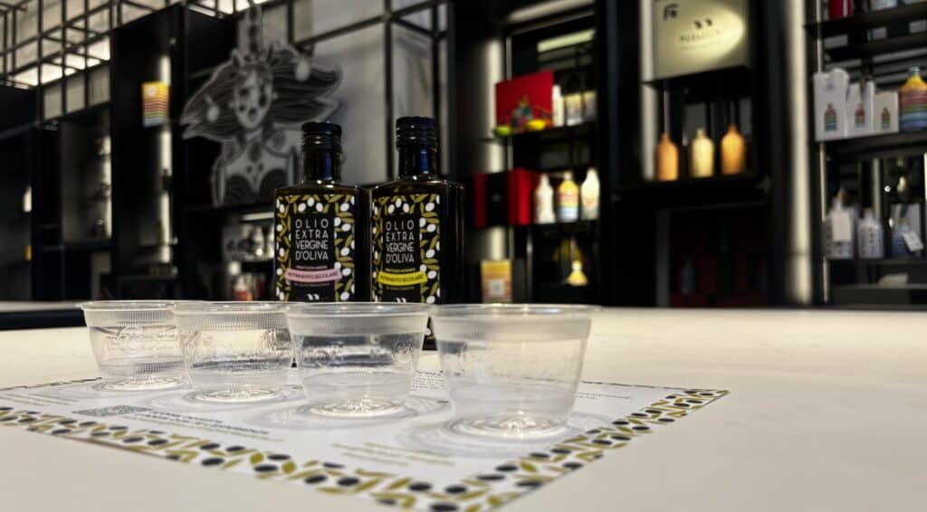 Degustazione di quattro oli extravergine nello showroom del Frantoio Muraglia ad Andria, con orci in ceramica sullo sfondo